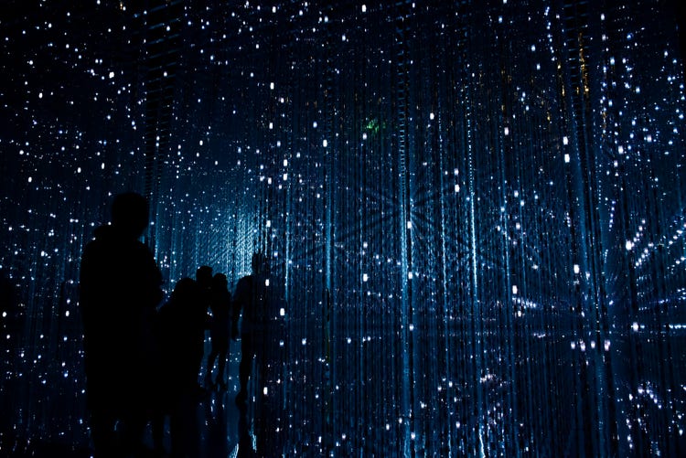 Commission people in a dark room with glass walls surrounded by small lights